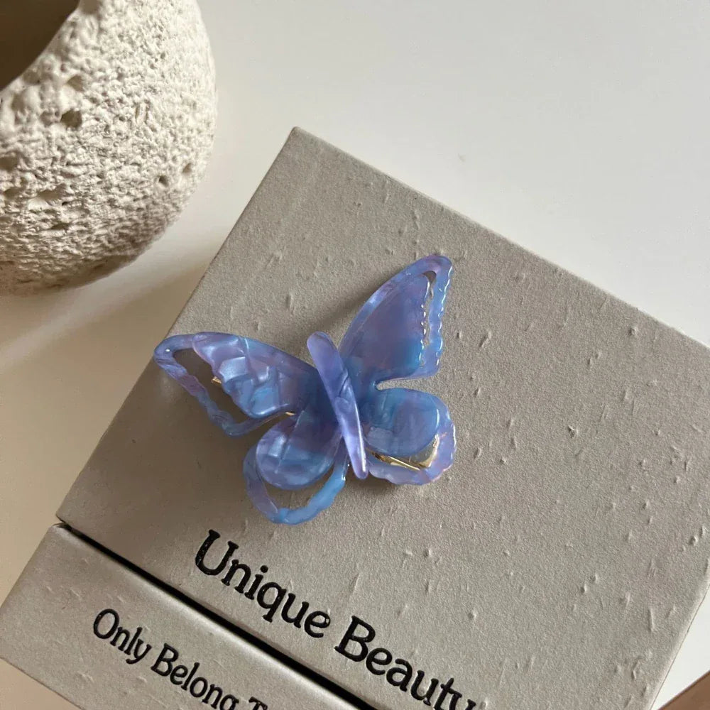 translucent purple butterfly hair clip on a grey box