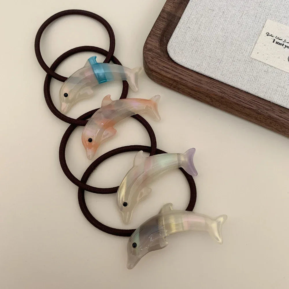 Several iridescent dolphin hair ties coiled together
