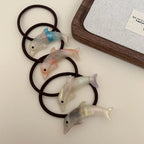 Several iridescent dolphin hair ties coiled together
