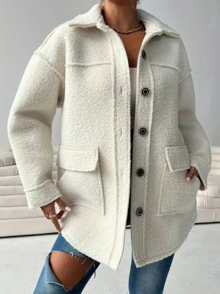 Front view of a woman wearing an oversized white sherpa fleece jacket, buttoned up.