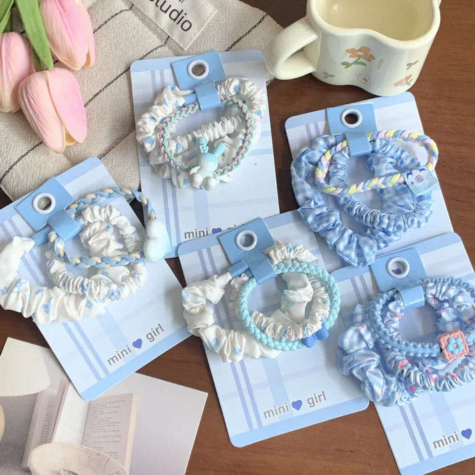 Collection of scrunchie sets with various blue and white patterns and charms Secondary image