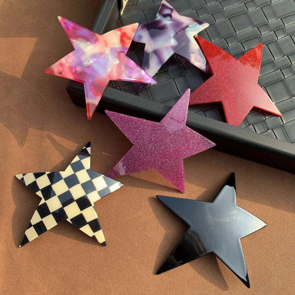 flat lay of star-shaped hair clips including checkered, black, pink, purple, and red designs