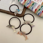 Collection of iridescent dolphin hair ties scattered on a surface