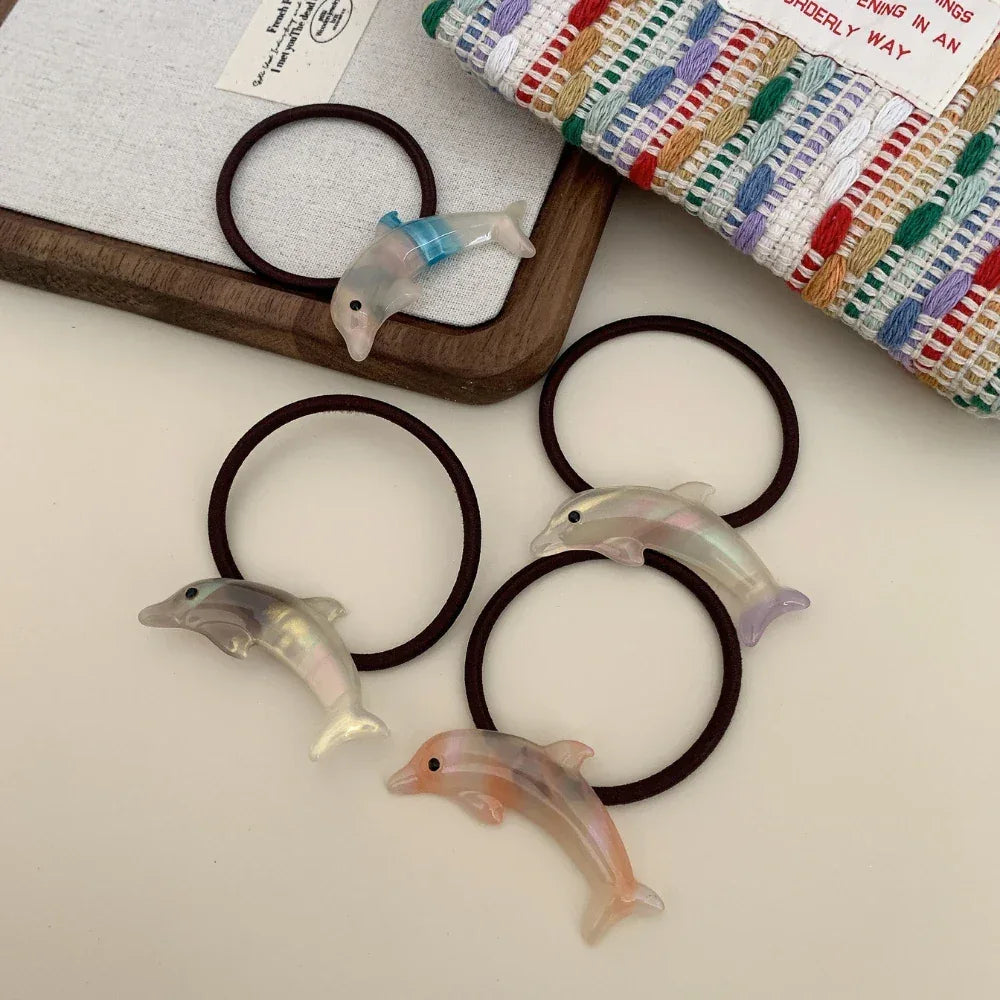 Collection of iridescent dolphin hair ties scattered on a surface