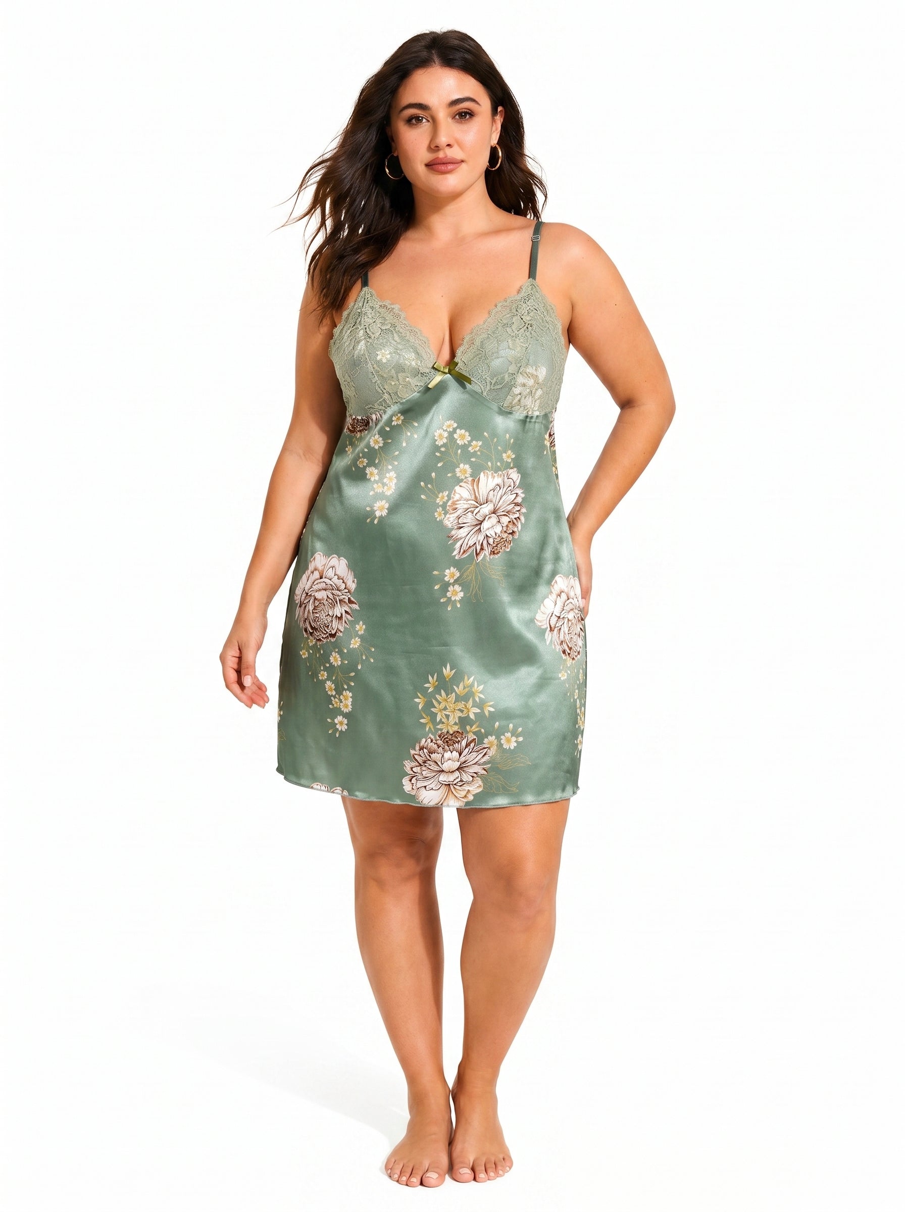 Full-body front view of a plus-size model in a green satin chemise featuring a floral print and lace neckline