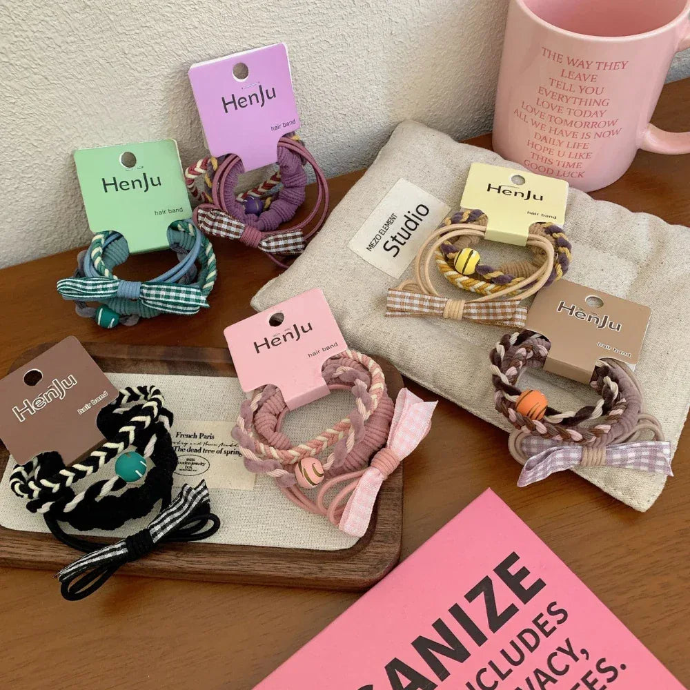 A collection of colorful hair ties with bows and braided details arranged on a table.