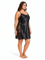 Plus size model wearing a black satin slip dress with lace side panels from a three-quarter side view.