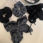 collection of scrunchies in black and grey with bow patterns and lace trim