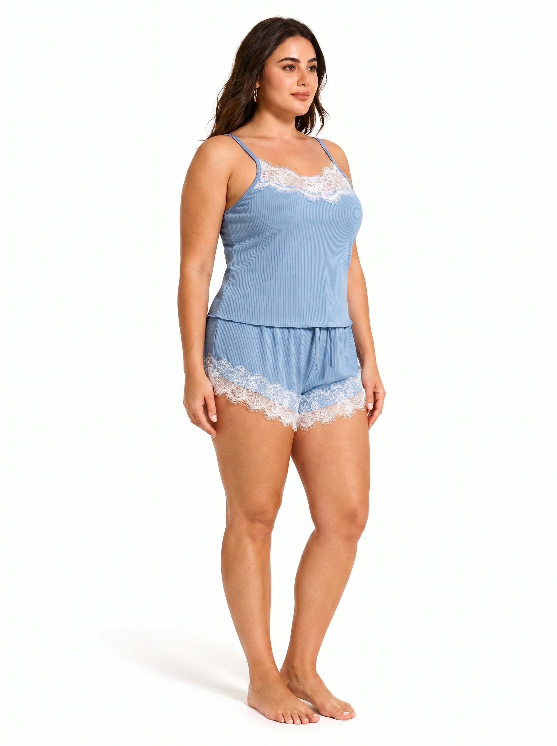 Back view of a woman in a blue camisole and shorts pajama set, highlighting the spaghetti straps and lace trim on the shorts.