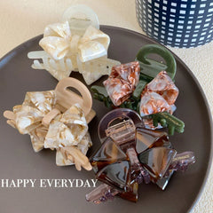 Assortment of bow claw clips on a dark plate with text overlay