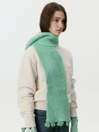 Model wearing a mint green fuzzy scarf draped around the neck