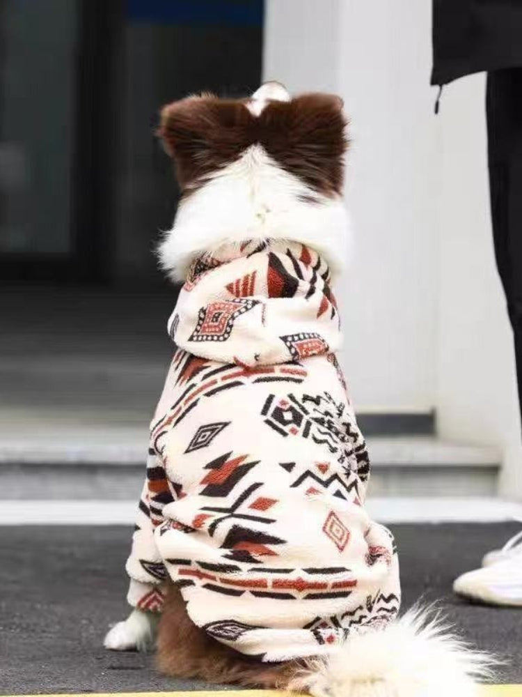 The back view of a brown and white Border Collie dog wearing a cream-colored fleece hoodie with a geometric pattern.