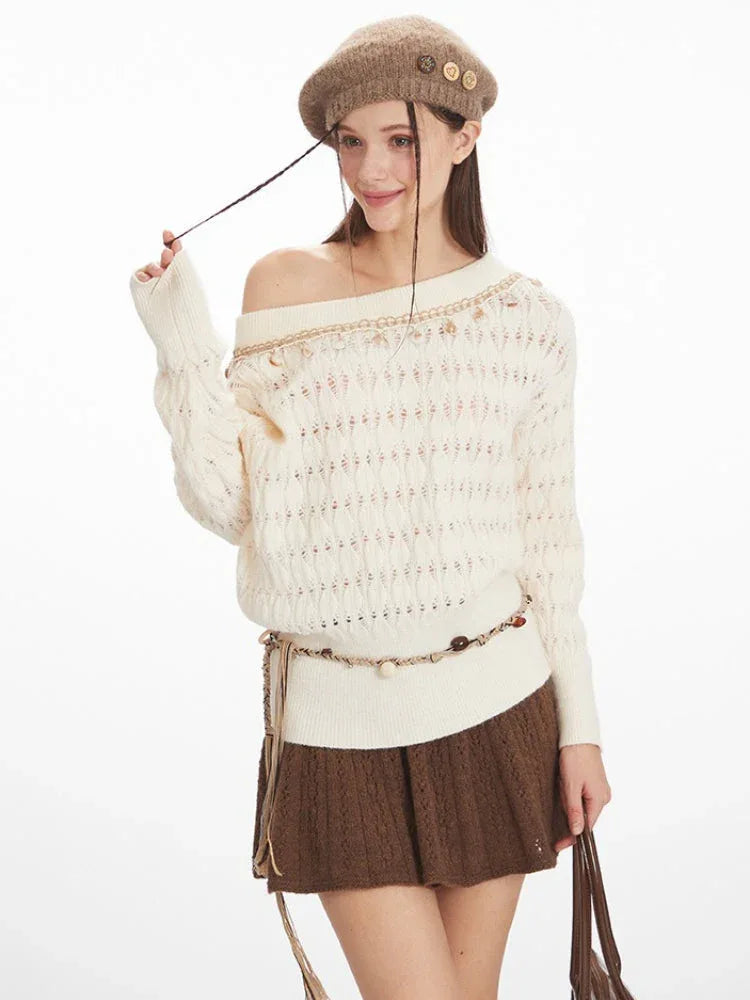 Close-up of a woman wearing a cream-colored off-the-shoulder knit sweater with a brown A-line skirt and brown beret.