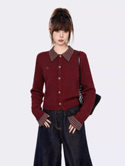 Front view of a woman in a burgundy cable knit cardigan with plaid accents.