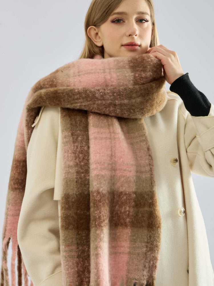 Woman's face framed by a thick, oversized plaid scarf in pink and brown.