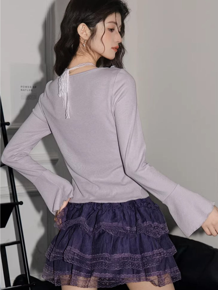 Back view of a woman wearing a lavender ribbed knit cardigan with lace trim and bell sleeves, paired with a purple tiered ruffled skirt.