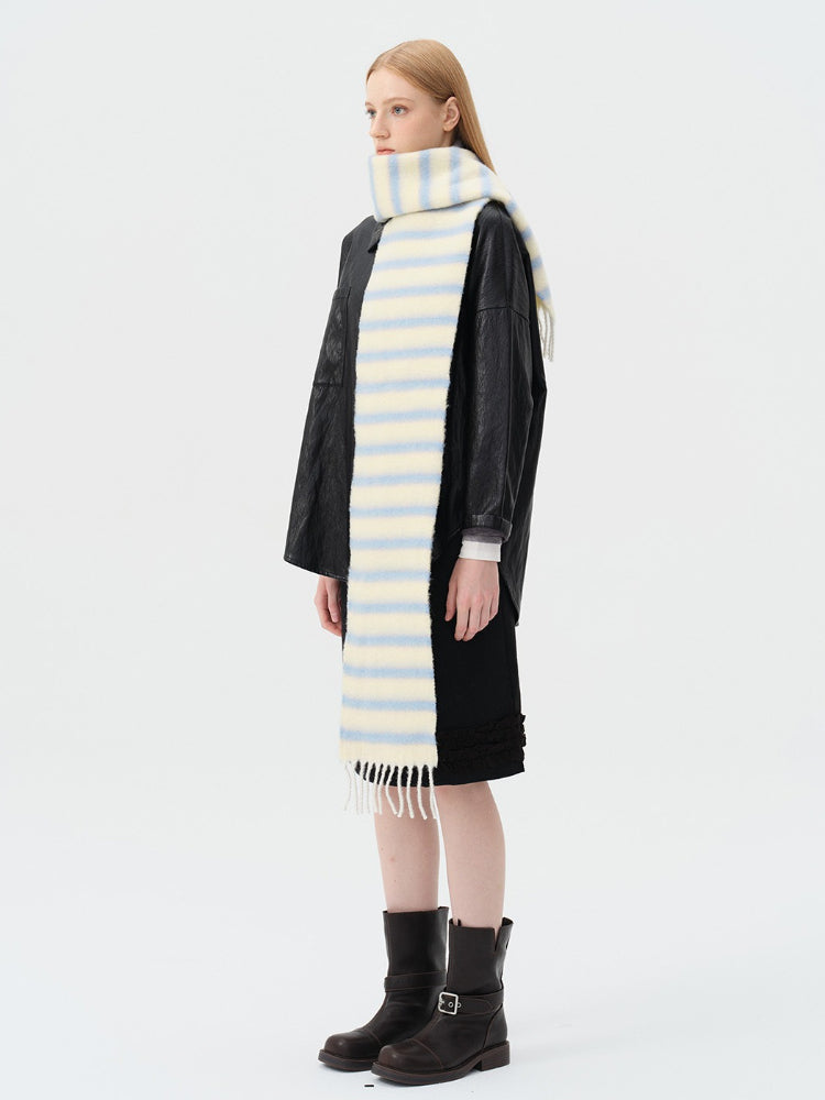 model wearing a black leather jacket and a light yellow and blue striped scarf
