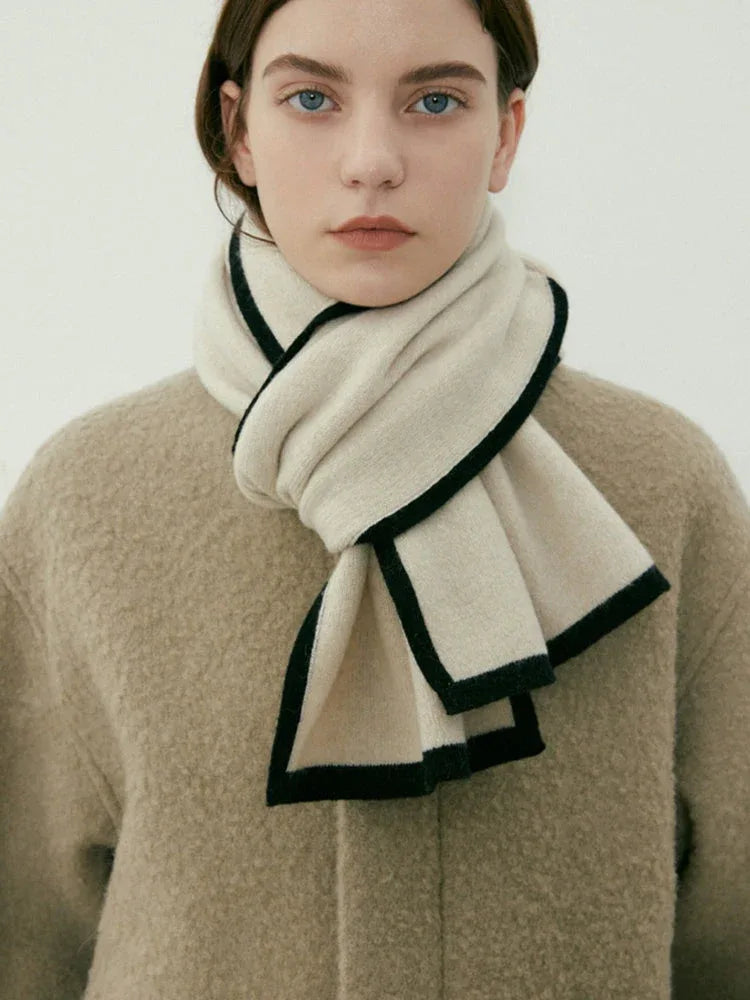 Close-up of a woman wearing a cream scarf with black trim