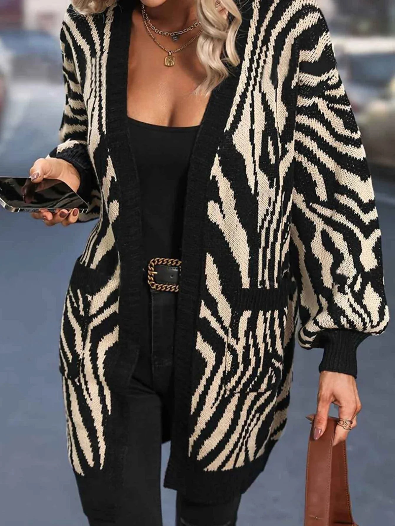Woman wearing a black and white zebra print longline knit cardigan with an open front. Main image