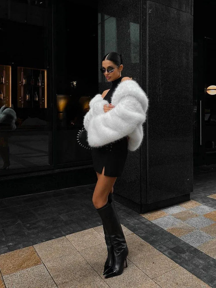 woman wearing a black mini dress with a white faux fur jacket and black boots Main image