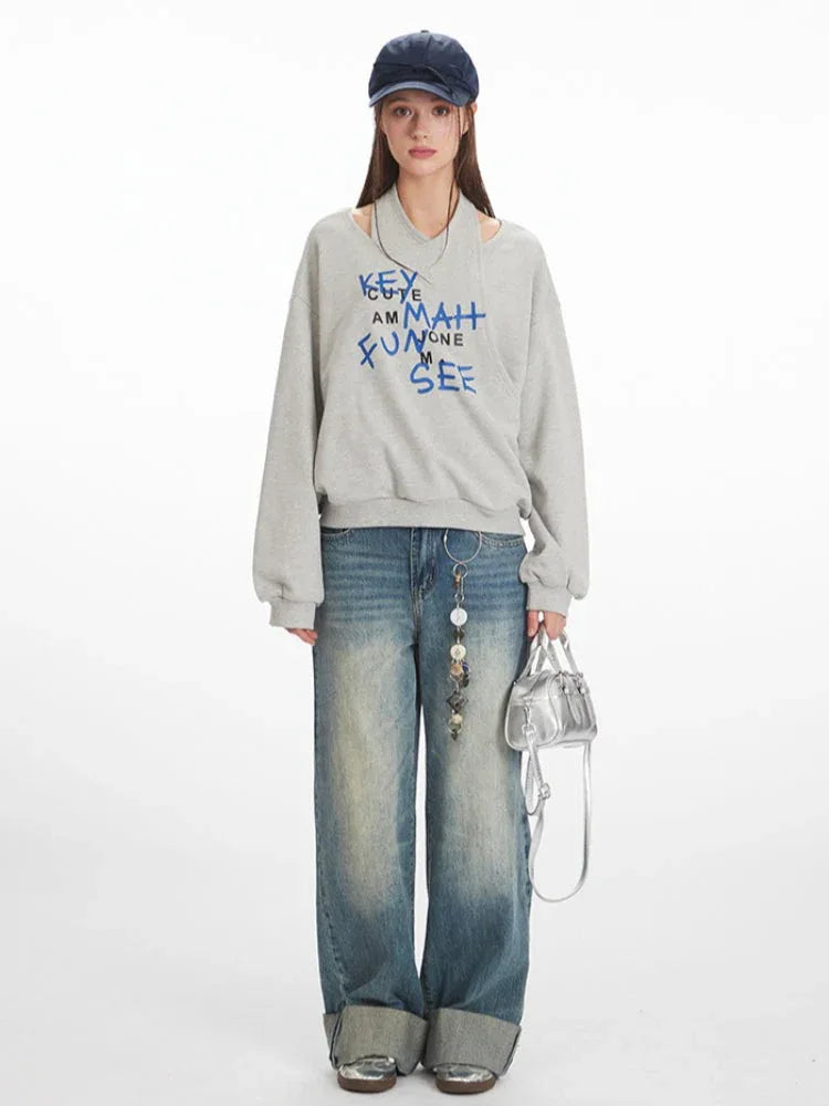 Model wearing a grey graphic print sweatshirt and wide-leg jeans, front view