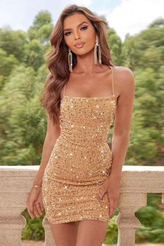 Woman wearing a gold sequin mini dress with spaghetti straps