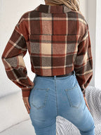 Back view of a model wearing a cropped plaid jacket and blue jeans.