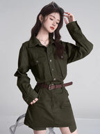 Close-up of a woman in a green shirt and skirt set, styled with a brown belt