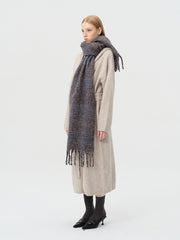 Side view of a model showcasing the plaid scarf draped around her neck.