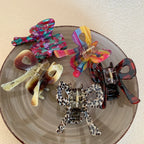Several bow hair clips of different patterns and colors on a plate