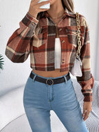 Model holding a white quilted handbag while wearing a cropped plaid jacket, white tank top, and blue jeans.