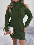 woman holding a white clutch and wearing a green knitted cold shoulder mock neck dress