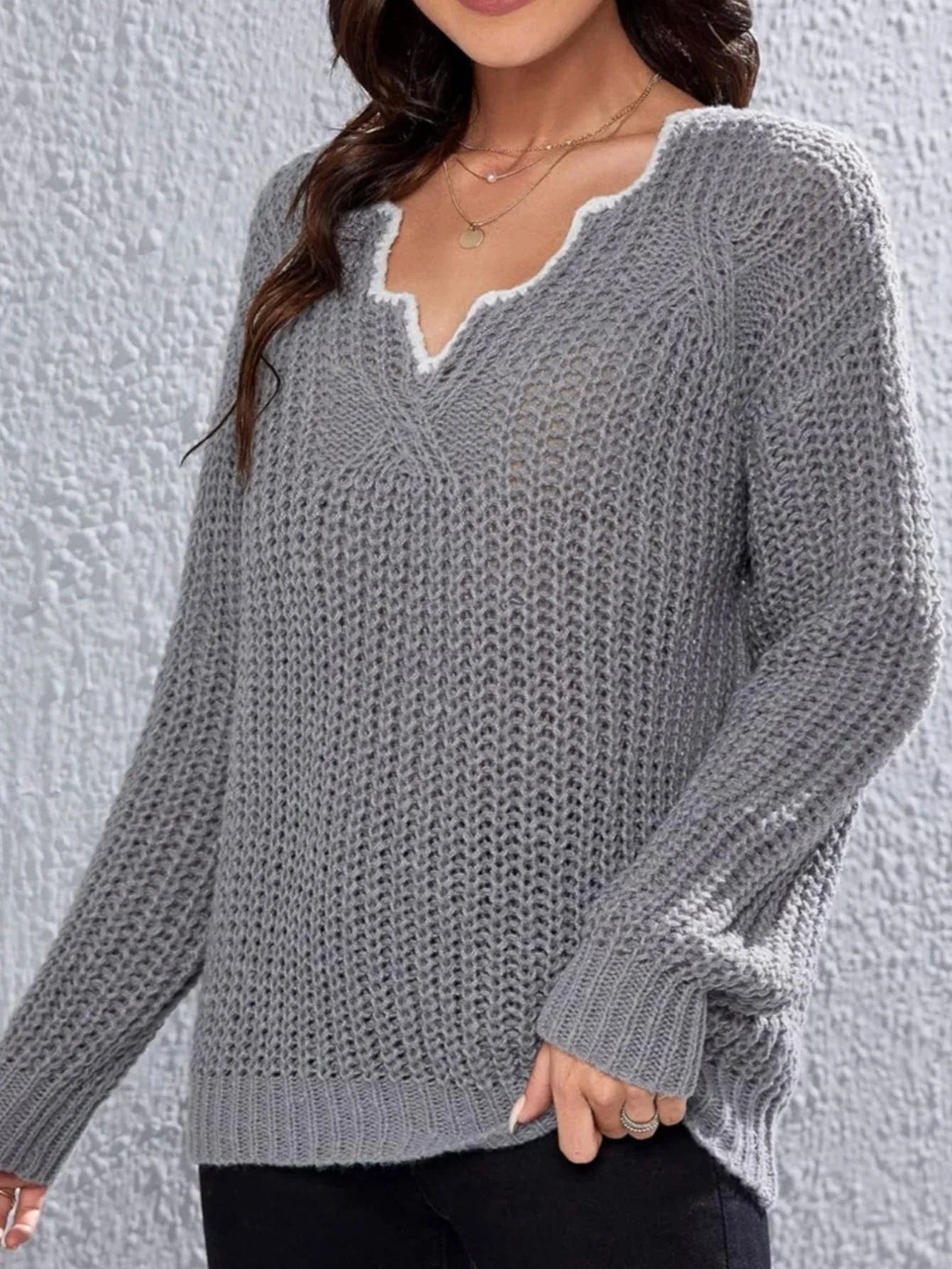 Close-up of the V-neck detail on a grey knit sweater
