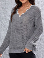 Close-up of the V-neck detail on a grey knit sweater