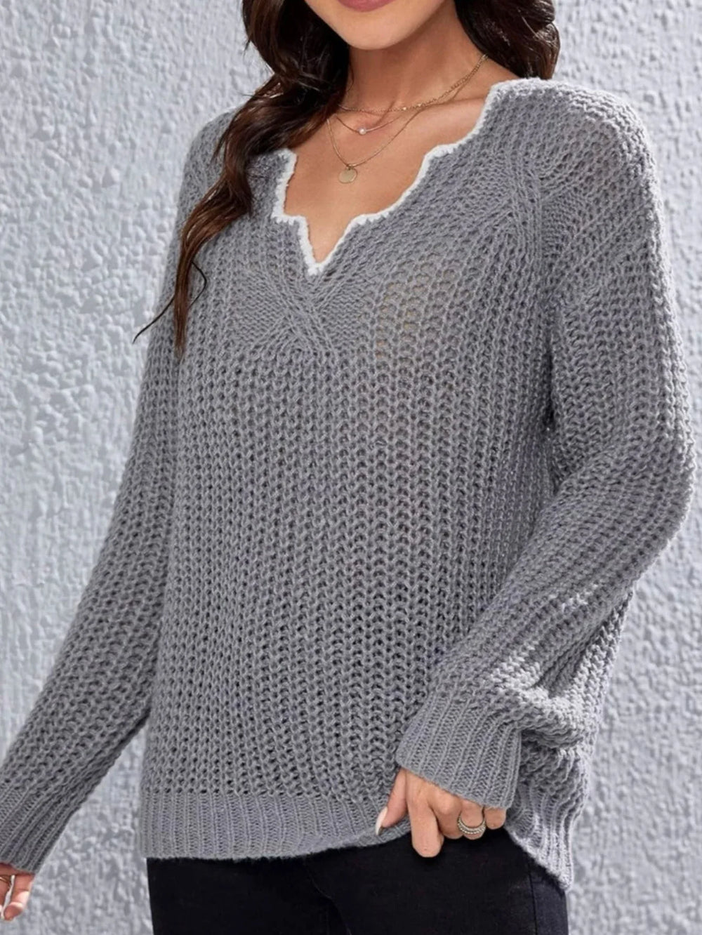 Close-up of the V-neck detail on a grey knit sweater