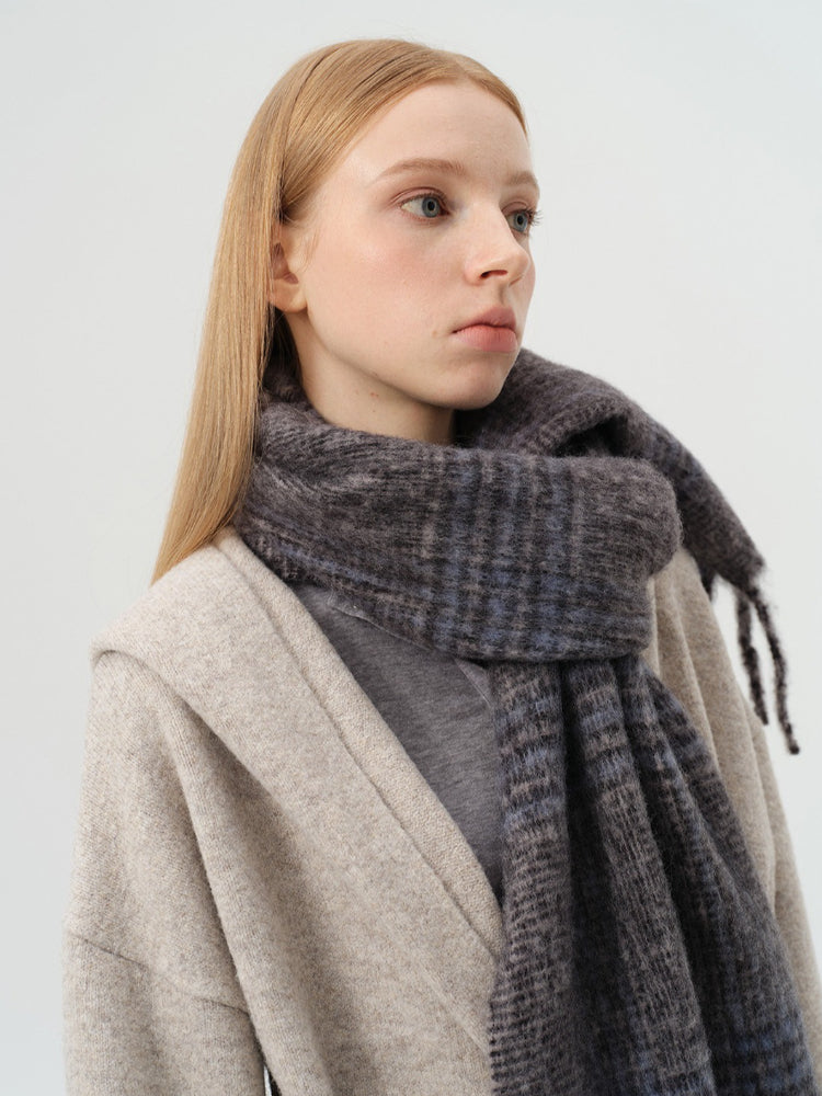 Detailed shot of the plaid pattern and fringe on the scarf.