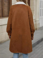 Back view of a woman wearing a long brown fleece jacket with sherpa collar.