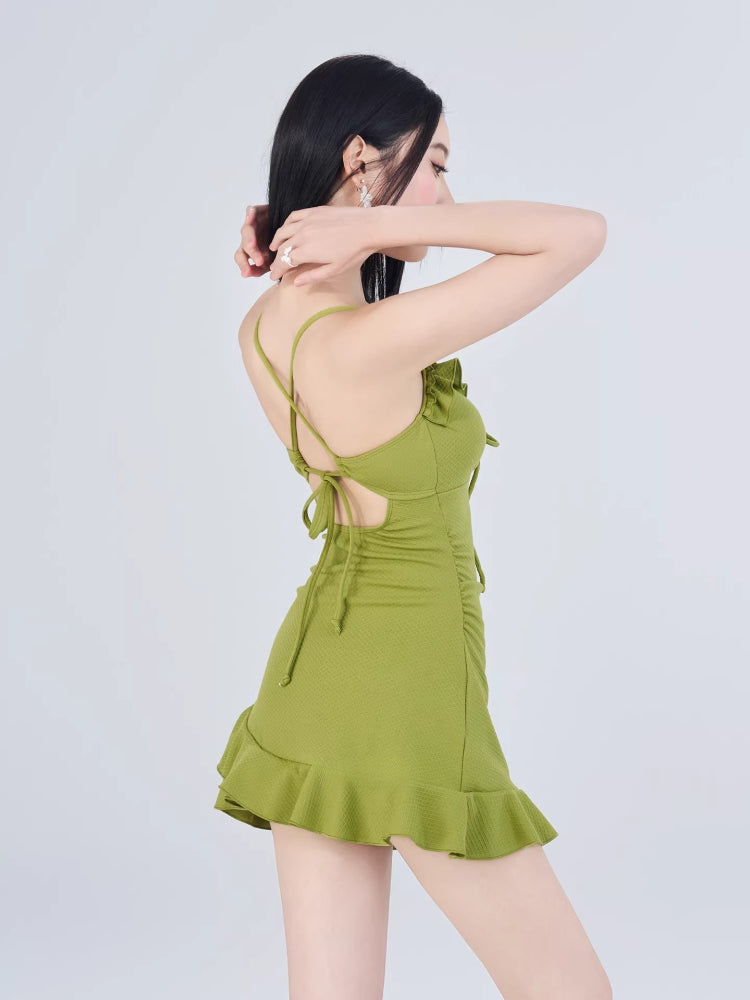 Back view of the green ruffled dress showing criss-cross straps