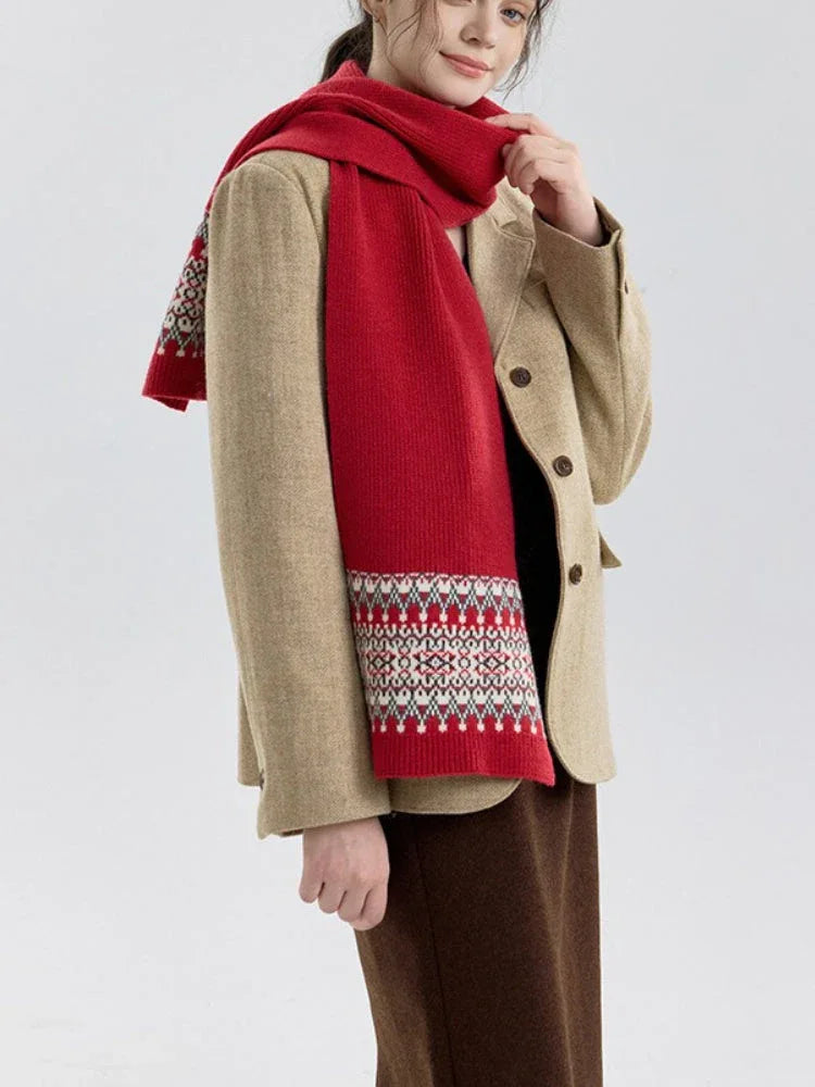 Side view of a woman wearing a red knit scarf with a Fair Isle pattern on the ends, over a tan blazer.