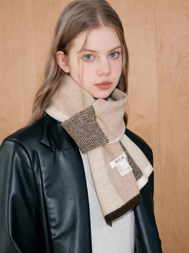 Woman with blue eyes wearing a neutral-toned plaid scarf.