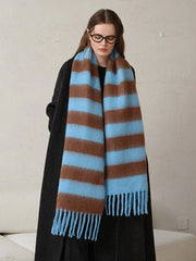 Woman modeling an oversized blue and brown striped scarf with fringe