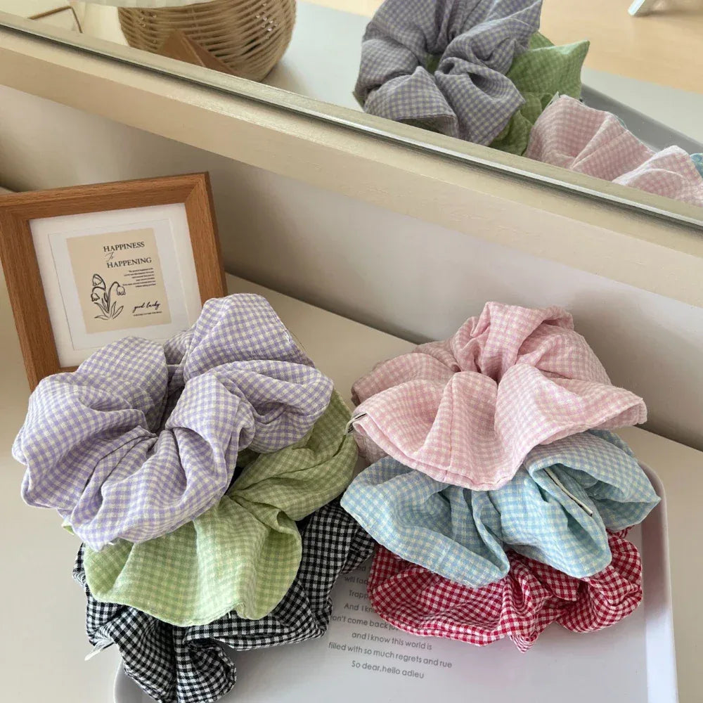 Collection of pastel and darker toned gingham scrunchies in a basket