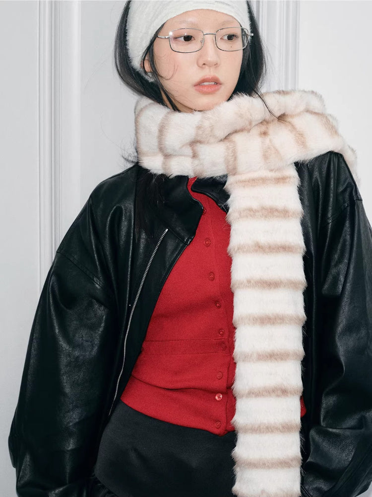 Model wearing a cream and brown striped faux fur scarf and a white ribbed headband, looking at the camera.