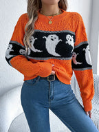 Close-up of a woman wearing an orange Halloween sweater with a ghost print, showing the texture and fit.
