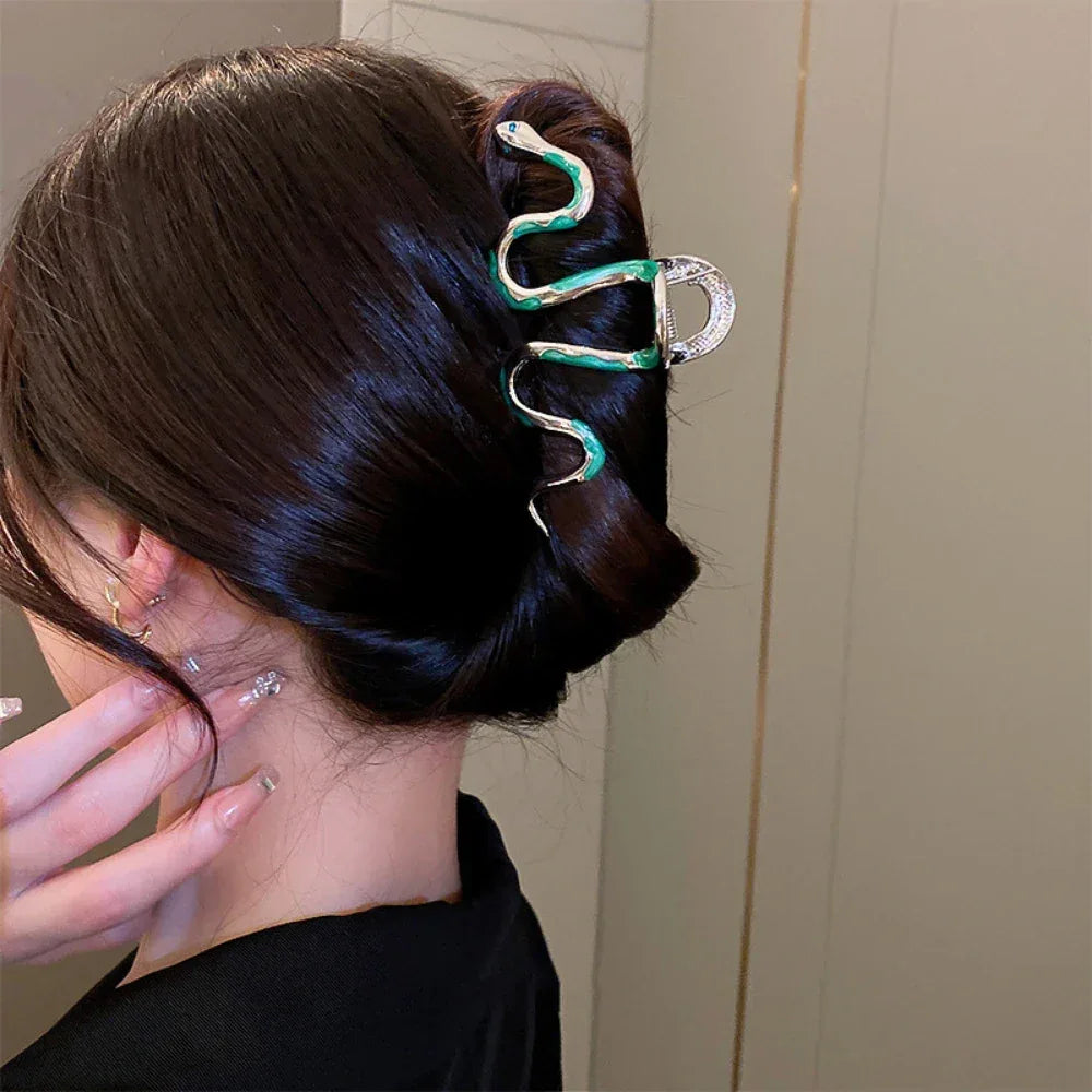 Woman with dark hair wearing a snake-shaped hair clip.