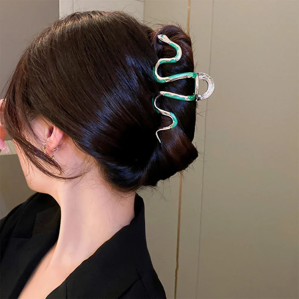 Close-up of a snake-shaped hair clip holding dark hair in a bun.