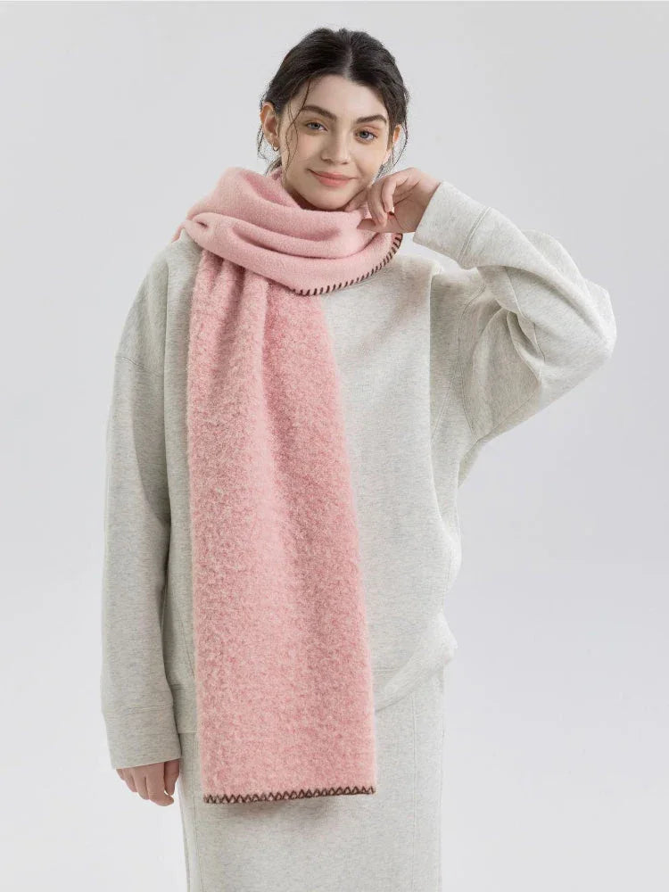 Woman wearing a pink fuzzy knit scarf and grey sweatshirt