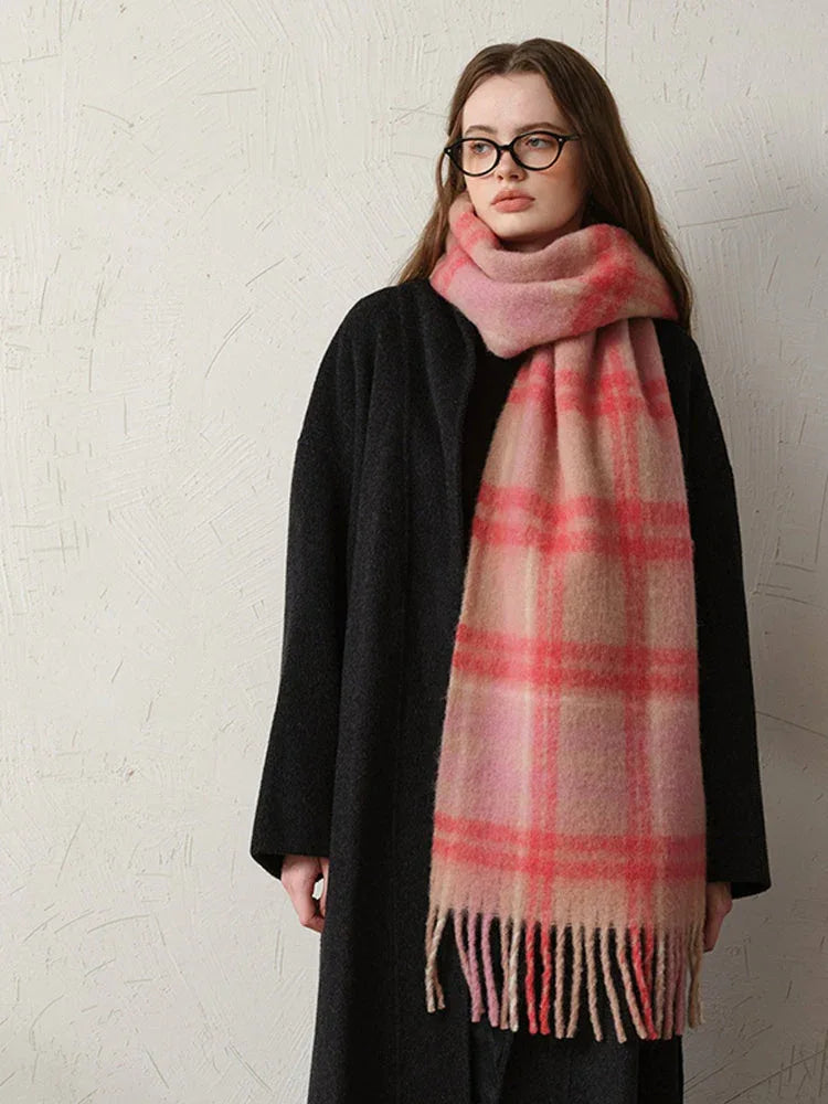 Close-up of a woman wearing a black coat and a pink plaid scarf.
