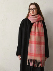 Close-up of a woman wearing a black coat and a pink plaid scarf.