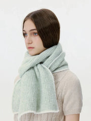 Woman wearing a light green ribbed knit scarf with white trim